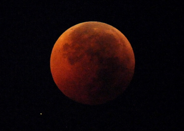 Une éclipse lunaire totale se produit lorsque la Terre projette son ombre sur la Lune. Le visage lunaire peut parfois devenir rougeâtre, brun cuivré ou orange, teinté par la lumière du Soleil qui se réfracte en traversant notre atmosphère. Photo JAY DIRECTO/AFP/Getty Images.