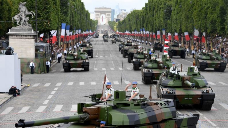 Les membres du 5e Régiment de dragons défilent sur les chars Leclerc lors du défilé militaire du 14 juillet  de l'année dernière sur les Champs-Elysées à Paris .Photo  ALAIN JOCARD/AFP/Getty Images.