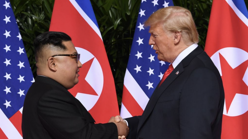  Le leader nord-coréen Kim Jong Un (à gauche) serre la main du président américain Donald Trump (à droite) à l'ouverture du sommet historique entre les États-Unis et la Corée du Nord, à Singapour le 12 juin 2018. - Donald Trump et Kim Jong Un sont devenus le 12 juin les premiers dirigeants américains et nord-coréens à se rencontrer, à se serrer la main et à négocier pour mettre fin à une impasse nucléaire vieille de plusieurs décennies. (SAUL LOEB/AFP/Getty Images)