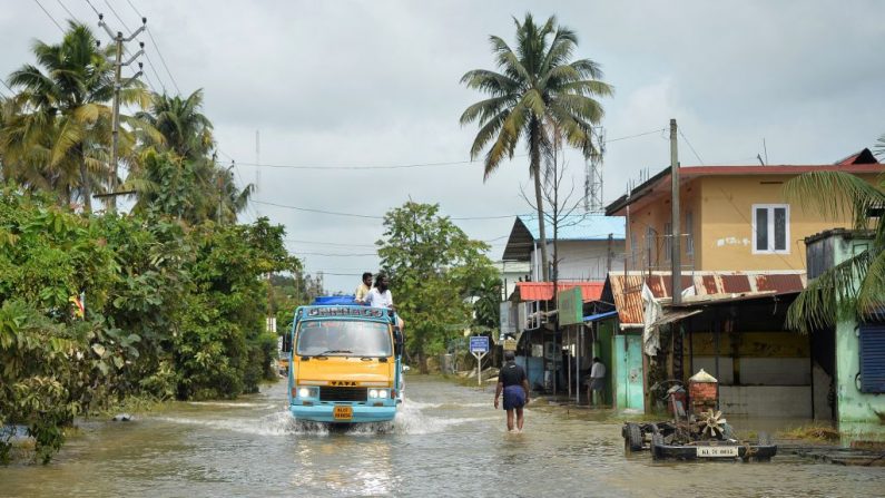 Le 20 août 2018, un mini-camion emprunte une route inondée dans l’état du Kerala, au sud de l’Inde.  La pire des moussons en un siècle dans l'État du Kerala, le nombre de morts ayant dépassé 400. Photo MANJUNATH KIRAN / AFP / Getty Images.