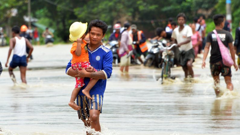 Les résidents sur une route inondée après les eaux déchaînées des villages submergés du barrage de Swar Chaung dans la région de Bago, au centre du Myanmar, le 29 août 2018. Photo  THET AUNG/AFP/Getty Images.