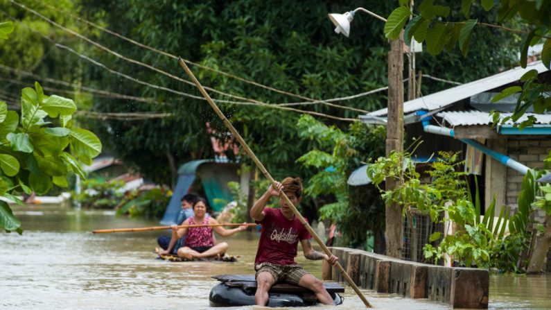 Le 31 août 2018, des résidents traversent une route inondée dans la région de Taungnu. - Plus de 63 000 personnes de la région de Bago ont été touchées par le débordement du barrage de Swar Chaung au début du 29 août. Photo YE AUNG THU / AFP / Getty Images.