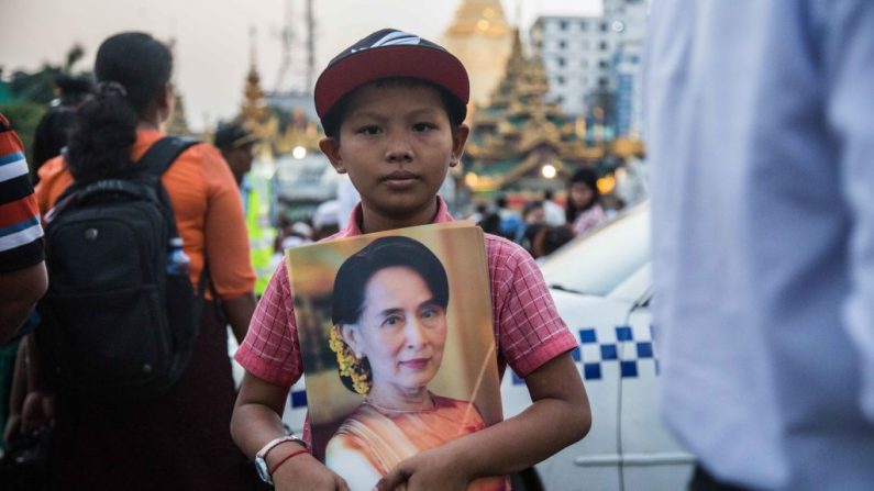 Un jeune garçon du Myanmar tient une affiche de Aung San Suu Kyi lors d'une cérémonie de prière interconfessionnelle organisée par la Ligue nationale pour la démocratie devant l'hôtel de ville le 31 octobre 2017. Photo Lauren DeCicca / Getty Images.