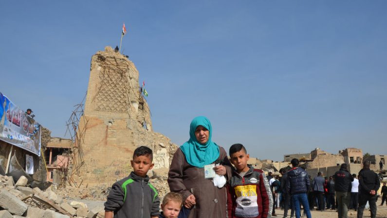 Les Irakiens se tiennent devant le minaret d'Al-Hadba détruit de la mosquée Al-Nuri de la vieille ville de Mossoul, lors d'un rassemblement pour appeler les organisations internationales à procéder à la reconstruction de la ville. Les forces irakiennes se sont emparées de la deuxième ville du pays par les djihadistes du groupe État islamique il y a sept mois. Photo : AHMAD MUWAFAQ / AFP / Getty Images.