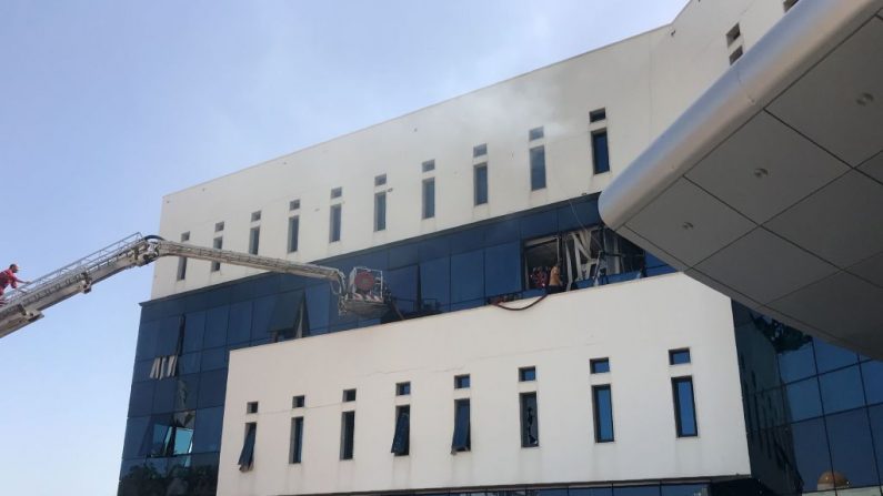 Les pompiers et les badauds se sont rassemblés devant le siège de la compagnie pétrolière nationale libyenne dans la capitale, Tripoli, le 10 septembre 2018. Des hommes armés ont attaqué le bâtiment à Tripoli. Photo MAHMUD TURKIA / AFP / Getty Images.