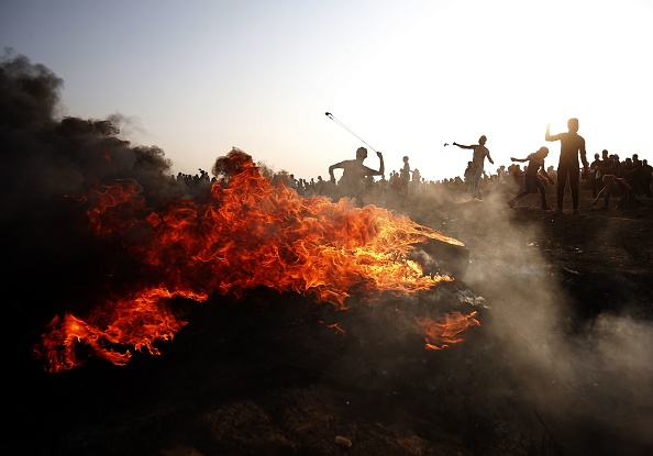 -Des manifestants palestiniens lancent des pierres sur les forces israéliennes lors d'affrontements le long de la barrière israélienne, à l'est de la ville de Gaza, le 28 septembre 2018. Photo : SAID KHATIB / AFP / Getty Images.