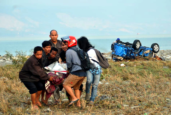-Les habitants transportent une victime après un tremblement de terre et un tsunami ayant frappé Palu, sur l'île de Sulawesi, le 29 septembre 2018. Photo MUHAMMAD RIFKI / AFP / Getty Images.