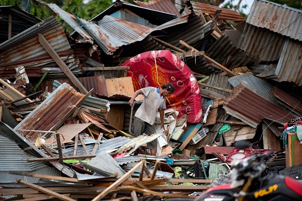 -Un homme cherche ses affaires au milieu des débris de sa maison détruite à Palu, dans le centre de Sulawesi, le 29 septembre 2018, après le tremblement de terre et le tsunami qui ont frappé la région. Photo BAY ISMOYO / AFP / Getty Images.