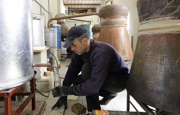 -Un Syrien distille dans le village de Marah, au nord de la capitale Damas. LOUAI BESHARA / AFP / Getty Images, illustration.
