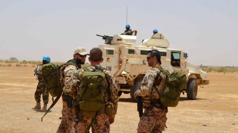 Des soldats allemands de la Mission multidimensionnelle intégrée des Nations Unies parlent à côté d'un véhicule blindé nigérian sur un site de cantonnement à Fafa, à 165 km de Gao. Photo  SOULEYMANE AG ANARA / AFP / Getty Images.