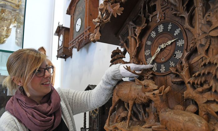 Une employée déplace les aiguilles d'une horloge historique au Musée allemand de l'horlogerie à Furtwangen, en Allemagne, le 19 mars 2018. (Patrick Seeger/AFP/Getty Images)