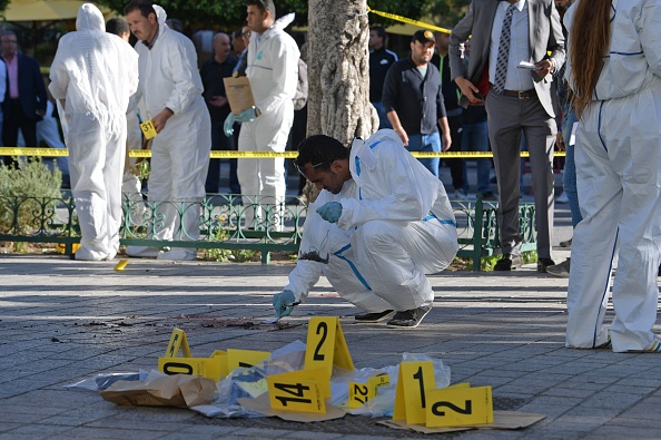 -Des médecins légistes tunisiens inspectent le site d'un attentat-suicide dans la capitale tunisienne, Tunis, le 29 octobre 2019. Une femme kamikaze s'est fait exploser près d'un véhicule de la police au centre de la capitale tunisienne, blessant au moins neuf personnes. Photo FETHI BELAID / AFP / Getty Images.