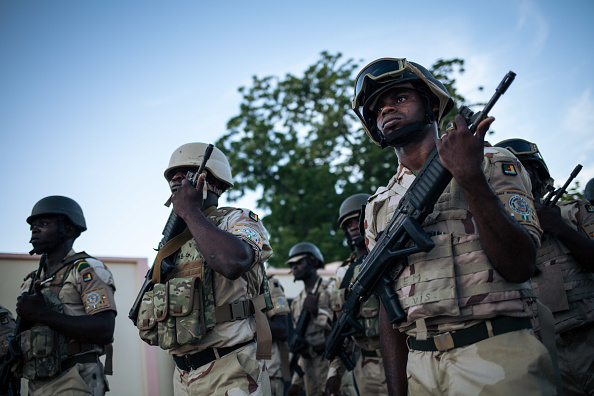 -Des soldats dirigent la cérémonie quotidienne d'abaissement du drapeau, le 28 septembre 2018. Depuis 2014, la région de l'Extrême-Nord du Cameroun est le théâtre d'un conflit opposant les forces islamistes nigérianes, groupe terroriste de Boko Haram et l'armée camerounaise. Photo ALEXIS HUGUET / AFP / Getty Images.