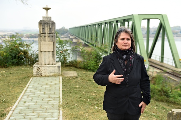 -La Directrice du musée Komarom, Emase Szamado pose devant un monument commémorant la Première Guerre mondiale sur la rive du Danube près de Komarom, en Hongrie, le 19 octobre 2018. Le pont dissimule des eaux troubles et des divisions qui remontent à un siècle et qui ne se sont apaisées que récemment. Photo par ATTILA KISBENEDEK / AFP / Getty Images.