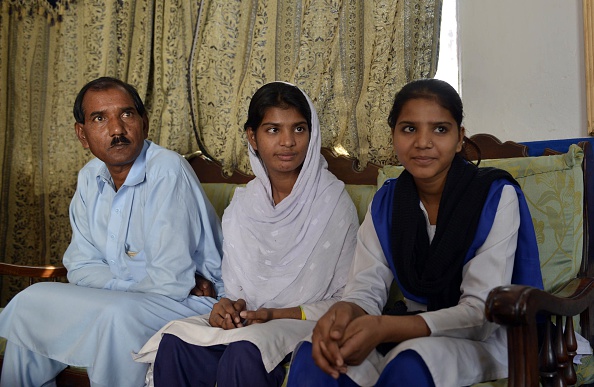 -Ashiq Masih le mari d’Asia Bibi, une mère chrétienne pakistanaise condamnée à mort aux termes de la loi sur le blasphème, s’assied avec ses filles Esham et Esha à leur résidence à Lahore. Son mari, vit caché à cause de la condamnation de sa femme. Photo Arif Ali / AFP / Getty Images.