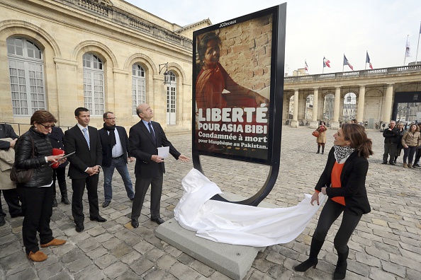 -Le maire de Bordeaux, Alain Juppé dévoile le 19 mars 2015 une affiche dans la cour de l'hôtel de ville de la ville du sud-ouest de la France, en l'honneur d'Asia Bibi, une chrétienne pakistanaise condamnée à mort depuis 2010. Photo de NICOLAS TUCAT / AFP / Getty Images.