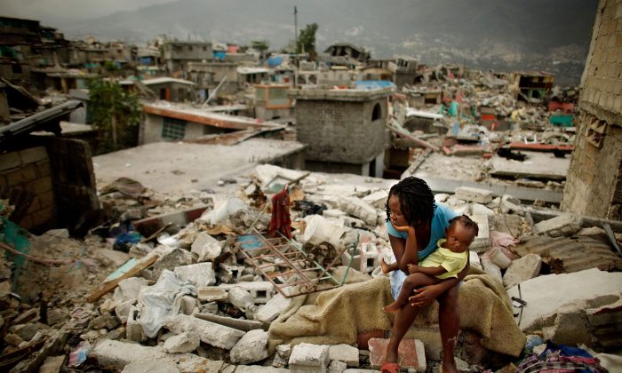 Sherider Anilus, 28 ans, et sa fille, Monica, 9 mois, sont assises sur les lieux où sa maison s'est effondrée lors du tremblement de terre de 2010 à Port-au-Prince, en Haïti. (Chip Somodevilla/Getty Images)