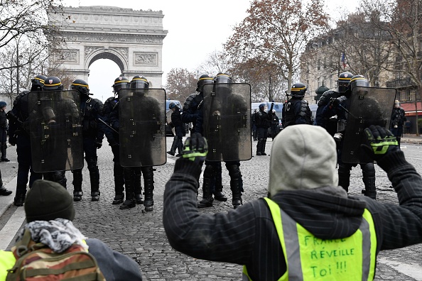 "gilets jaunes" à Paris à genoux devant les forces de l'ordre.     (Photo : BERTRAND GUAY/AFP/Getty Images)