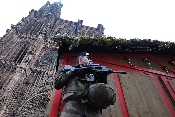 -Un soldat français monte la garde sur le marché de Noël situé devant la cathédrale, le 12 décembre 2018, alors que des policiers effectuent une perquisition afin de retrouver le tireur qui a ouvert le feu près d'un marché de Noël la nuit précédente, à Strasbourg, dans l'est de la France. Photo PATRICK HERTZOG / AFP / Getty Images.