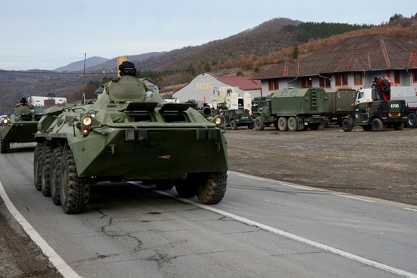 -Le 13 décembre 2018, des soldats de la mission de maintien de la paix au Kosovo dirigée par l'OTAN (KFOR) conduisent leurs véhicules tandis que les troupes se garent près de Leposavic, une municipalité principalement serbe au Kosovo. Photo de STR / AFP / Getty Images.