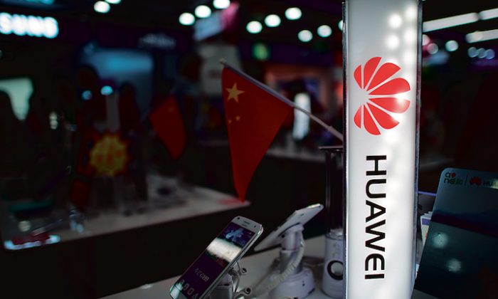Un logo de Huawei à côté d'un drapeau chinois à Shanghai, le 1er octobre 2014. (JOHANNES EISELE/AFP/Getty Images)