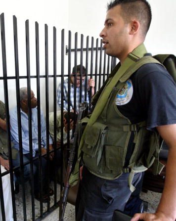 -(Illustration) La sécurité palestinienne veille sur 2 personnes au siège de la sécurité, condamnée à mort pour avoir collaboré avec Israël. Photo de Ahmad Khateib / Getty Images.