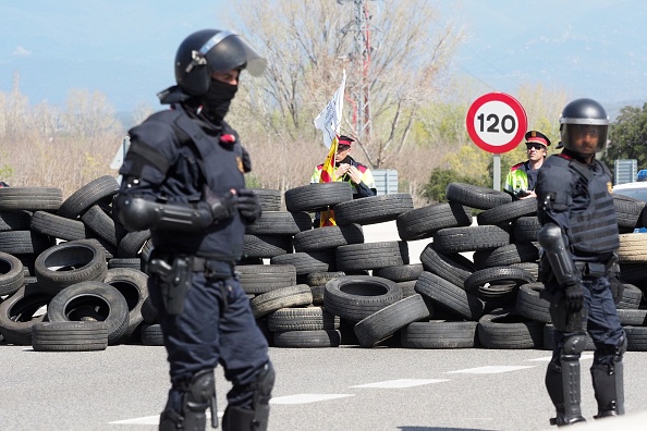 -Un policier anti-émeute espagnol monte la garde après la levée par la police d'un barrage routier établi par des séparatistes catalans sur l'autoroute AP-7 reliant l'Espagne à la France. Photo RAYMOND ROIG / AFP / Getty Images.