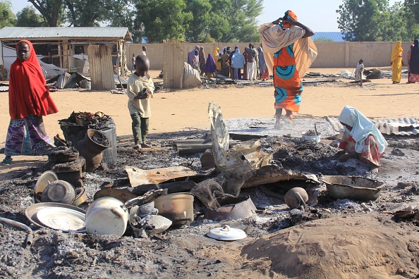 -Des enfants tentent de récupérer des objets de valeur dans une maison incendiée après les multiples attaques des islamistes de Boko Haram à Dalori et dans d'autres villages voisins à l'extérieur de Maiduguri, dans le nord-est du Nigéria 2018. Photo AUDU MARTE / AFP / Getty Images.