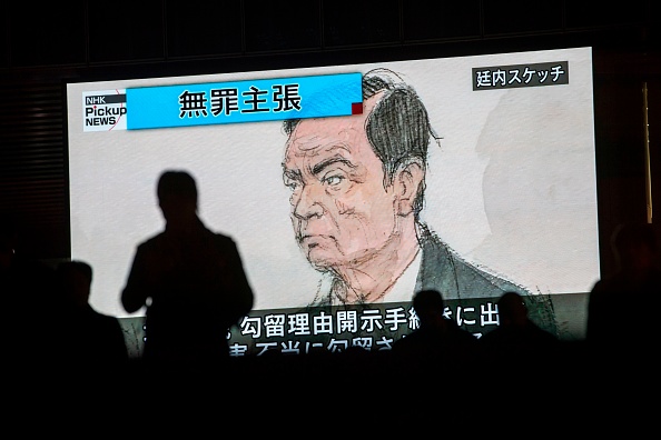 -Les piétons passent devant un écran de télévision diffusant un reportage présentant un croquis de l'ancien chef de Nissan, Carlos Ghosn, dans la salle d'audience, à Tokyo, le 8 janvier 2019, comme l'indique le titre japonais intitulé « Innocence ». Photo BEHROUZ MEHRI / AFP / Getty Images.