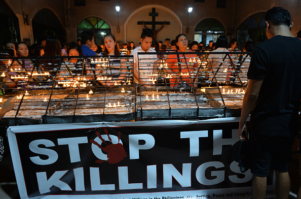 -Des fidèles catholiques allument des bougies pendant qu'ils prient lors d'une messe pour toutes les victimes de l’attentat dans une église. Photo TED ALJIBE / AFP / Getty Images.
