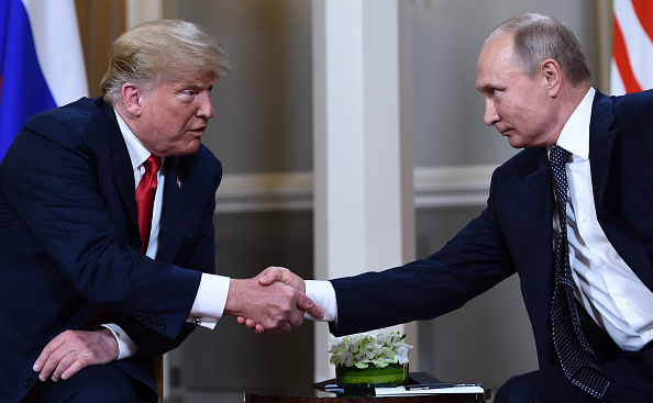 -Le président russe, Vladimir Poutine et le président américain, Donald Trump, se serrent la main avant une réunion à Helsinki, le 16 juillet 2018. Photo de Brendan Smialowski / AFP / Getty Images.