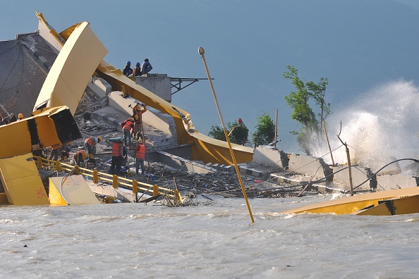 -Illustration- Cette photo prise à Palu le 26 octobre 2018 montre des ouvriers indonésiens travaillant sur un pont endommagé, touché par le séisme et le tsunami à Palu. Le séisme meurtrier en Indonésie a laissé de nombreux enfants orphelins. Photo par OLAGONDRONK / AFP / Getty Images.