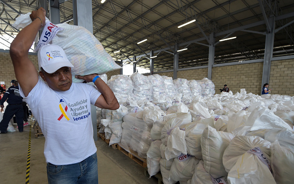Un volontaire porte un sac contenant de l'aide humanitaire américaine à Cucuta, en Colombie, le 8 février 2019, à la frontière avec Tachira au Venezuela. Des officiers de l'armée vénézuélienne ont bloqué un pont à la frontière avec la Colombie en prévision d'un envoi d'aide humanitaire. (Photo : RAUL ARBOLEDA/AFP/Getty Images)