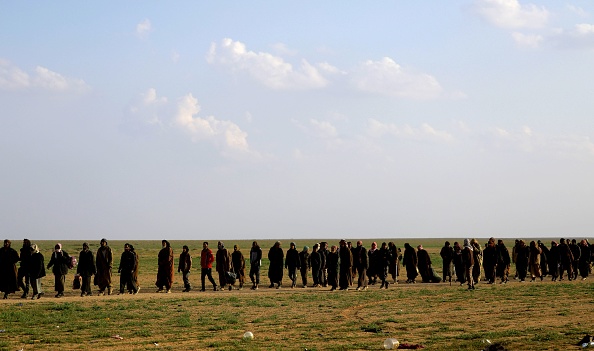 Des hommes soupçonnés d'être des combattants de l'État islamique (IS) attendent d'être fouillés par des membres des SDF dirigées par des Kurdes après avoir quitté la dernière résistance du groupe IS à Baghouz, dans la province de Deir Ezzor, au nord du pays, le 22 février 2019.   (Photo  : SOULEIMAN/AFP/Getty Images)