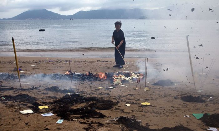 Un ouvrier brûle des offrandes sur une plage au temple de Joss House pour célébrer le festival Tin Hau à Hong Kong le 10 mai 2015. (Dale de la Rey/AFP/Getty Images)