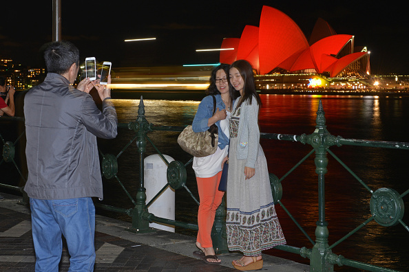 -Des touristes chinois prennent des photos devant l'Opéra de Sydney qui est allumé en rouge pour accueillir le nouvel an lunaire à Sydney le 8 février 2016. Photo PETER PARKS / AFP / Getty Images.