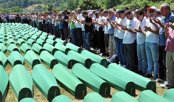 -Les musulmans de Bosnie, prient près des cercueils de leurs proches. Les corps sont identifiés comme appartenant à des victimes musulmanes de Bosnie. Au cours de l'offensive, plus de 8 000 non-Serbes de Bosnie ont été portés disparus. Ils ont été retrouvés inhumés dans des fosses communes des années après la fin de la guerre. Photo ELVIS BARUKCIC / AFP / Getty Images.