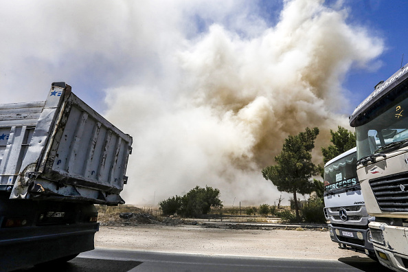 -Une photo prise le 10 juillet 2018 montre de la fumée qui monte à la suite de la démolition par le gouvernement syrien d'un tunnel utilisé autrefois par les rebelles dans la banlieue nord-est de Damas, Qaboun. Photo de LOUAI BESHARA / AFP / Getty Images.