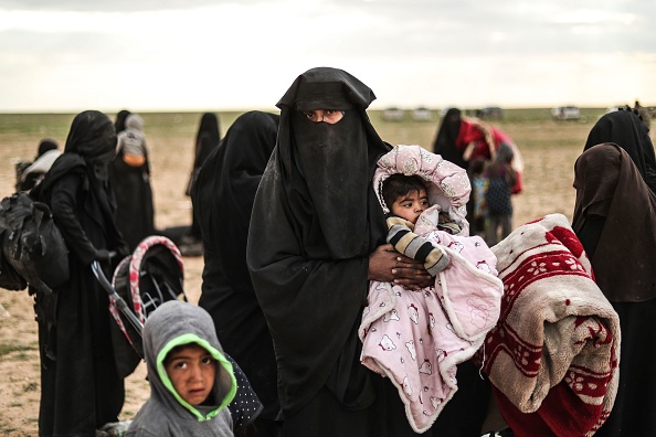 Une islamiste de Daesh ayant fui la ville de Baghouz en Syrie avec ses enfants est photographiée le 27 février 2019 alors qu’elle attend d’être examinée et interrogée par les soldats des Forces démocratiques syriennes (FDS). Photo d’illustration. Crédit : DELIL SOULEIMAN/AFP/Getty Images.