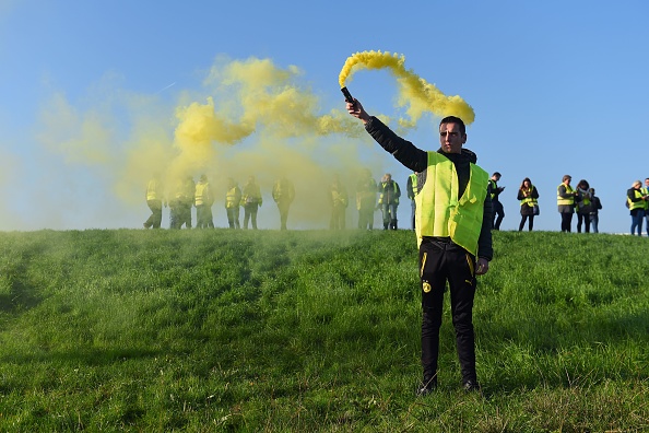 "Gilets jaunes" : un homme tient une fusée éclairante lors d'une manifestation contre la hausse des prix du carburant et du pétrole le 17 novembre 2018 à Bordeaux, sud-ouest de la France. (Photo :  NICOLAS TUCAT/AFP/Getty Images)