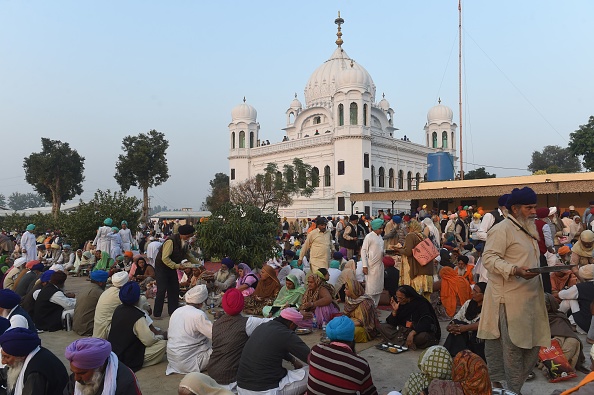 -Des pèlerins sikhs mangent devant le Kartarpur Gurdwara Sahib après une cérémonie d'inauguration du couloir Kartarpur. Le Premier ministre pakistanais, Imran Khan, a inauguré la cérémonie d'inauguration du couloir religieux entre l'Inde et le Pakistan. Photo par ARIF ALI / AFP / Getty Images.
