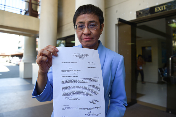 -Maria Ressa, PDG et rédactrice en chef du portail en ligne Rappler, montre l'ordre d'arrêté après avoir déposé une caution devant un tribunal de Manille le 3 décembre 2018. Photo TED ALJIBE / AFP / Getty Images.