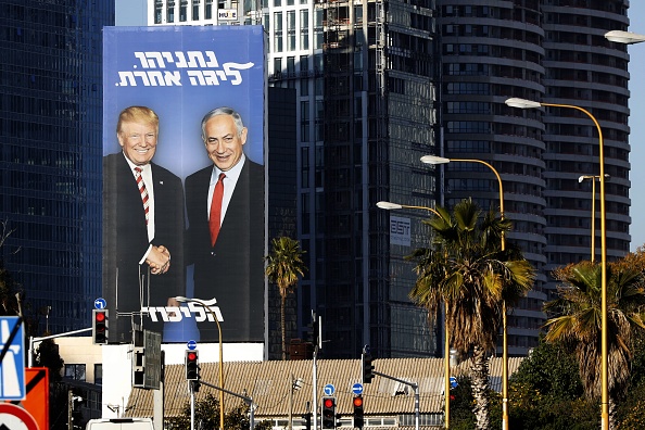 -Une photo prise le 3 février 2019 dans la ville côtière israélienne de Tel Aviv montre un panneau électoral géant du premier ministre israélien Benjamin Netanyahu et du président américain Donald Trump qui se serrent la main. Photo de JACK GUEZ / AFP / Getty Images.