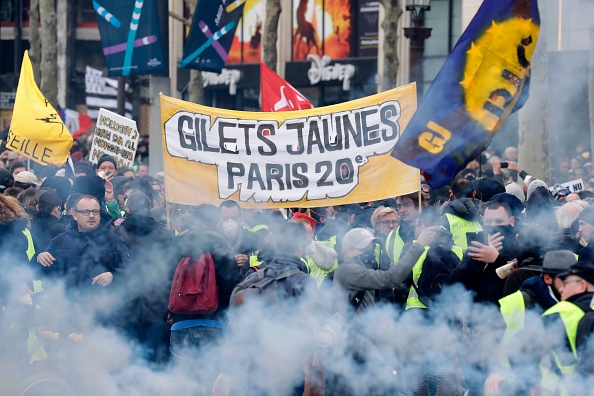 Les manifestants des "gilets jaunes" brandissent des drapeaux régionaux sur les Champs-Élysées à Paris, lors du 18e samedi consécutif de manifestations appelées par le mouvement des "gilets jaunes". (Photo : THOMAS SAMSON/AFP/Getty Images)