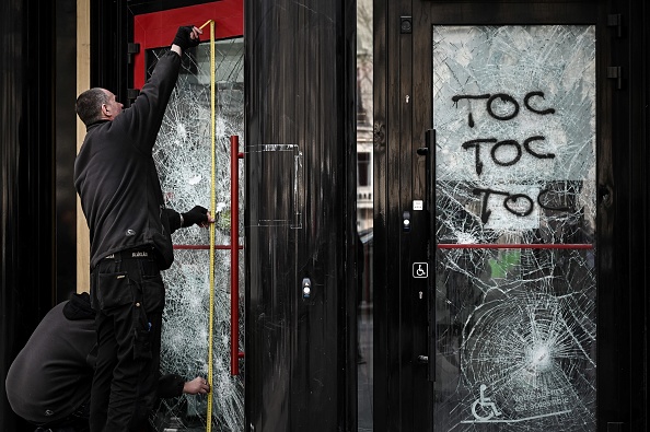 Remplacement d'une vitre brisée d'une banque à Paris le 18 mars 2019,  lors d'affrontements avec les forces de l'ordre sur les Champs-Élysées, le 18e samedi consécutif de manifestations organisées par le mouvement " Gilets jaunes ".   (Photo :  PHILIPPE LOPEZ/AFP/Getty Images)
