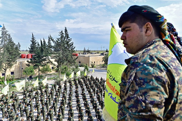 -Le 23 mars, des forces dirigées par les Kurdes ont annoncé la mort du "califat" du groupe de l'État islamique. À Al-Omar, un champ pétrolifère utilisé comme principale base de rassemblement des FDS pour la phase finale de l'assaut, des combattants dans leur meilleure tenue, ils ont déposé les armes et se sont mis à chanter et à danser. Photo by GIUSEPPE CACACE / AFP /Getty Images.