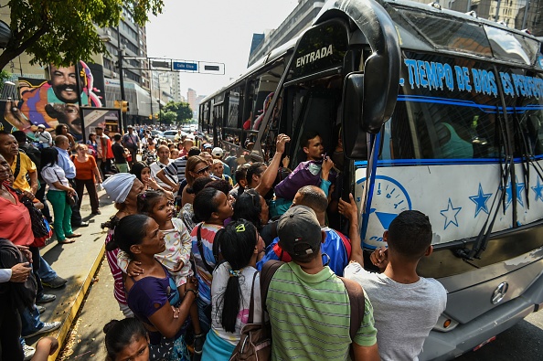 People queue to get on a bus during a partial power cut in Caracas, on March 25, 2019. - A new power outage hits large areas of Venezuela on Monday, including Caracas, two weeks after the massive March 7 blackout that paralyzed the country for a week. (Photo by Juan BARRETO / AFP)        (Photo credit should read JUAN BARRETO/AFP/Getty Images)
