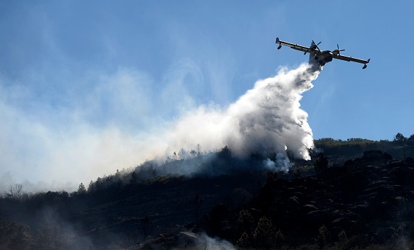 -Un hydravion fait tomber de l'eau sur un feu de forêt qui brûle en Galice, dans le nord-ouest de l'Espagne. Photo MIGUEL RIOPA / AFP / Getty Images.