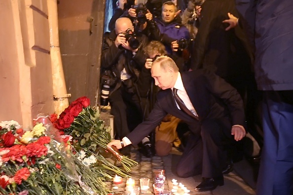 -Le 3 avril 2017, le président russe Vladimir Poutine place des fleurs à la mémoire des victimes de l'explosion dans le métro de Saint-Pétersbourg, à l'extérieur de la station de l'Institut technologique. Photo de STR / AFP / Getty Images.