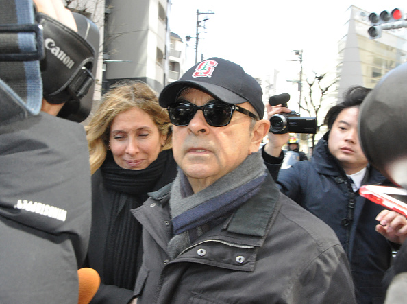 -L'ancien président de Nissan, Carlos Ghosn, et son épouse, Carole, sont encerclés par les médias lors de leur passage à Tokyo, le 9 mars 2019. Photo par JIJI PRESS / JIJI PRESS / AFP / Getty Images.